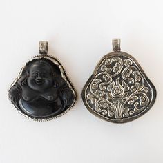 Smiling Buddha Pendant Black Matte Obsidian The pendant is set in set in Tibetan silver bezels which are created in the ancient process of repousse, hammering or punching the metal to create a beautiful relief design. Tibetan silver is not real silver but made up of different metals and can have a small trace of nickel. It looks like antiqued silver. Beautiful inspiring repoussed designs on the back side of each piece. 1 Pendant ~51mm both ways Bale hole ~7.5 Handcrafted in the Himalayan Kingdom Black Spiritual Jewelry With Antique Finish, Black Hand Cast Pendant Necklace, Black Hand-cast Pendant Necklace, Black Amulet Jewelry With Oxidized Finish, Black Oxidized Amulet Jewelry, Spiritual Hand Cast Black Necklace, Smiling Buddha, Relief Design, Buddha Pendant