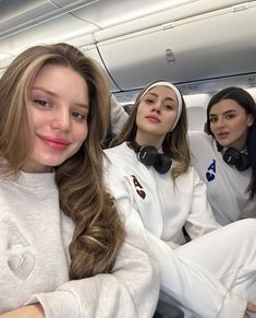 three women sitting in the back of an airplane