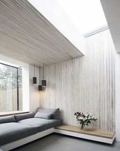 a living room filled with furniture next to a window covered in white slatted walls