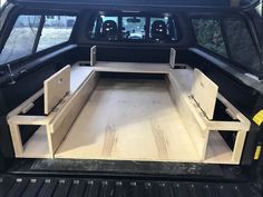 the back end of a truck that has been built with drawers and shelves in it