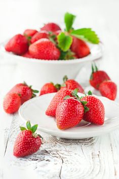 five strawberries lined up on a white surface