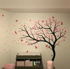 a baby's room with a tree painted on the wall