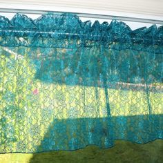 a green curtain hanging from the side of a window