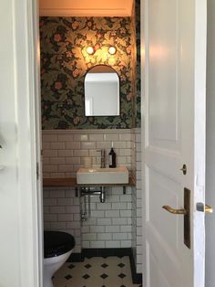 an open door leading to a bathroom with black and white floor tiles on the walls