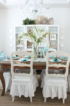 the dining room table is set with white chairs