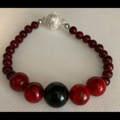 Red Beads With One Black Onyx Bead With Sterling Silver Swarovski Magnet Closure. 8 Inch Elegant Red Beaded Necklace With Black Beads, Elegant Red And Black Beaded Necklaces, Elegant Red And Black Beaded Necklace, Elegant Red Gemstone Beads, Elegant Beaded Bracelets With Large Beads, Red Bracelets With Black Round Beads, Onyx Beaded Bracelets With Round Beads, Formal Bracelet With Black Beads, Red Round Beads For Formal Occasions