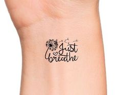 a wrist tattoo with the words just breathe written on it and dandelions in black ink