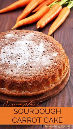 a cake sitting on top of a wooden table next to carrots