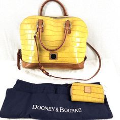 Minor Corner Wear See Pics This Dooney And Bourke Satchel Is A Must-Have For Any Stylish Woman. The Beautiful Yellow Leather Exterior Is Accented With A Studded Design And A Strap Detail. The Bag Has A Trapezoid Shape With Double Handles And A Shoulder Strap For Versatile Carrying Options. It Also Features A Zippered Closure And Interior Pockets For Easy Organization. The Bag Is Medium-Sized With A Width Of 12 Inches, A Height Of 10 Inches, And A Depth Of 5 Inches. It Comes With A Detachable Str Yellow Textured Leather Travel Bag, Trapezoid Shape, Easy Organization, Dooney And Bourke, Yellow Leather, Dooney & Bourke Bags, Dooney & Bourke, Red Fabric, Leather Satchel