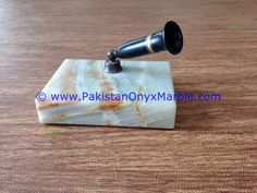 a marble block with a black telescope on it's end sitting on a wooden table