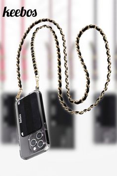 a cell phone is hanging from a chain with the words keebos on it