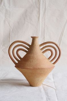 a brown vase sitting on top of a white table