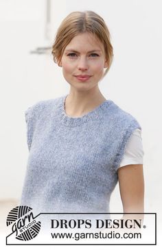 a woman standing in front of a white wall