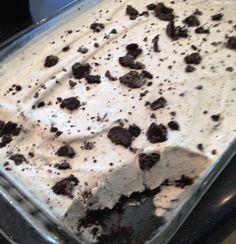 an ice cream dessert in a glass dish with chocolate chips on the top and white icing