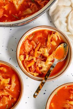 three bowls of soup with spoons on the side and one bowl filled with pasta