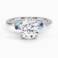 a white gold ring with blue and white diamonds on it's shants, set in 18k white gold