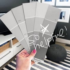 a person holding up five different shades of paint in front of a computer desk with the word inspire written on it