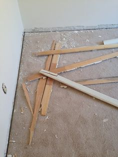 several pieces of wood are laying on the floor next to a hole in the wall