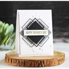 a father's day card sitting on top of a piece of wood next to a plant