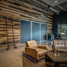 a living room with couches and chairs in front of a wooden paneled wall