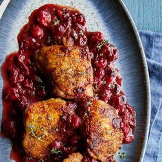 three pieces of meat with cranberry sauce on a plate