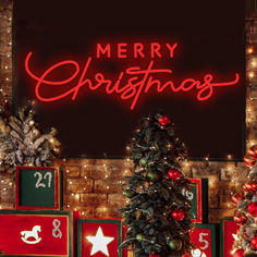 a christmas tree with red and green ornaments in front of a brick wall that reads merry christmas