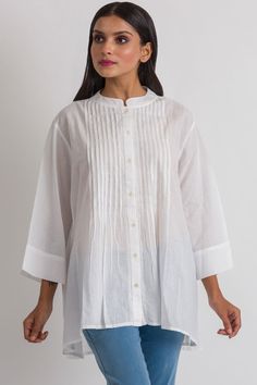 "Our Rajani Tunic is hand embroidered by women artisans in Northern India in the shadow-work style known as \"Chikankari\" on soft 100% cotton fabric. Chikankari is a delicate and artfully done hand embroidery technique that women in this region have been doing for generations. This elegant tunic features a Nehru collar, button down front with pleats, and exquisite hand embroidery on the back.  This style is free size, and is designed for a comfortable fit up to size XXL." Traditional Straight Kurta With Pintucks, Cotton Straight Kurta With Pintucks, Elegant Cotton Kurta With Cutdana, Folk Style Embroidered Top With Woven Motifs, Elegant Cotton Kurta With Floral Embroidery, White Cotton Kurta With Relaxed Fit, White Cotton Relaxed Fit Kurta, Traditional Pintucks Kurta, White Relaxed Fit Cotton Kurta