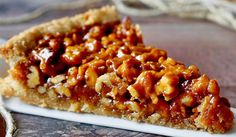 a piece of pecan pie sitting on top of a white plate