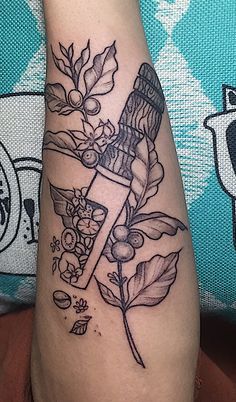 a tattoo on the leg of a person with a bottle and flowers in front of it