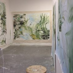 an empty room with paintings on the walls