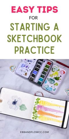 an open sketchbook with watercolors and pencils on the table next to it