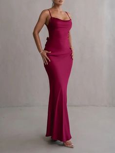 a woman in a pink dress posing for the camera with her hands on her hips