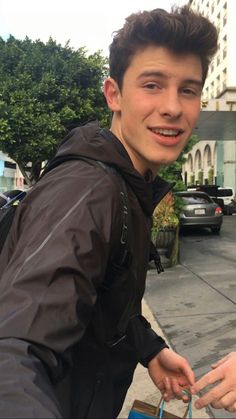 a young man holding onto a blue bag