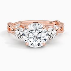 a rose gold engagement ring with three stone accents