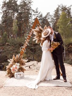 a bride and groom kissing in front of a welcome sign