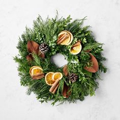 a christmas wreath with oranges, cinnamons and pine cones on it's side