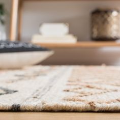 a close up view of a rug on the floor with a bowl in the background