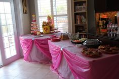 a table covered in pink cloths with food on it