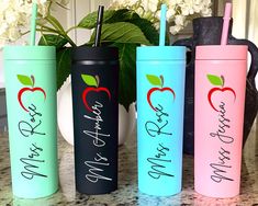 three different colored tumblers with straws in them sitting on a counter next to a potted plant