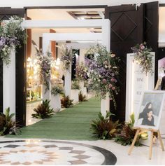 an indoor wedding ceremony with flowers and greenery on the aisle, surrounded by white pillars