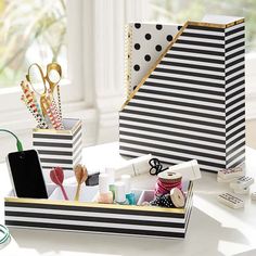 two black and white boxes with various items in them sitting on a table next to each other