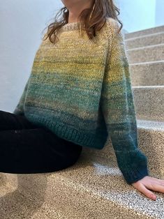 a woman is sitting on the stairs with her legs crossed