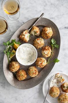 small appetizers are served on a platter with dipping sauce