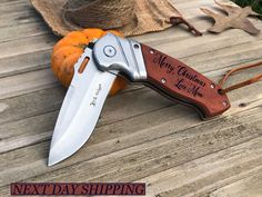 a knife that is sitting on top of a wooden table next to some pumpkins