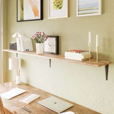 a wooden table topped with a laptop computer sitting on top of a wooden desk next to a window