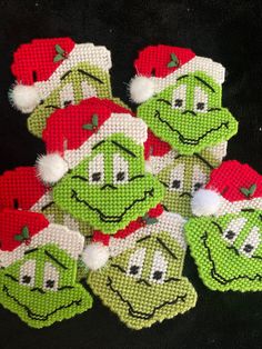 some green and red christmas ornaments with santa hats on them, all decorated to look like smiling faces