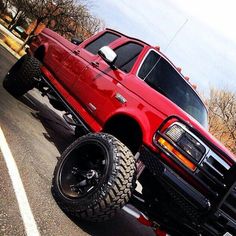 a red pick up truck parked in a parking lot