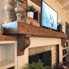 a living room with a fire place and television on the wall above it's mantle