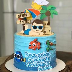 a birthday cake with an image of a boy in the sand and a beach scene on top