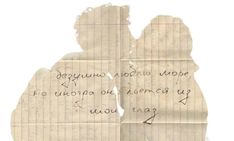 two people are facing each other and one is holding the handwritten letter to them